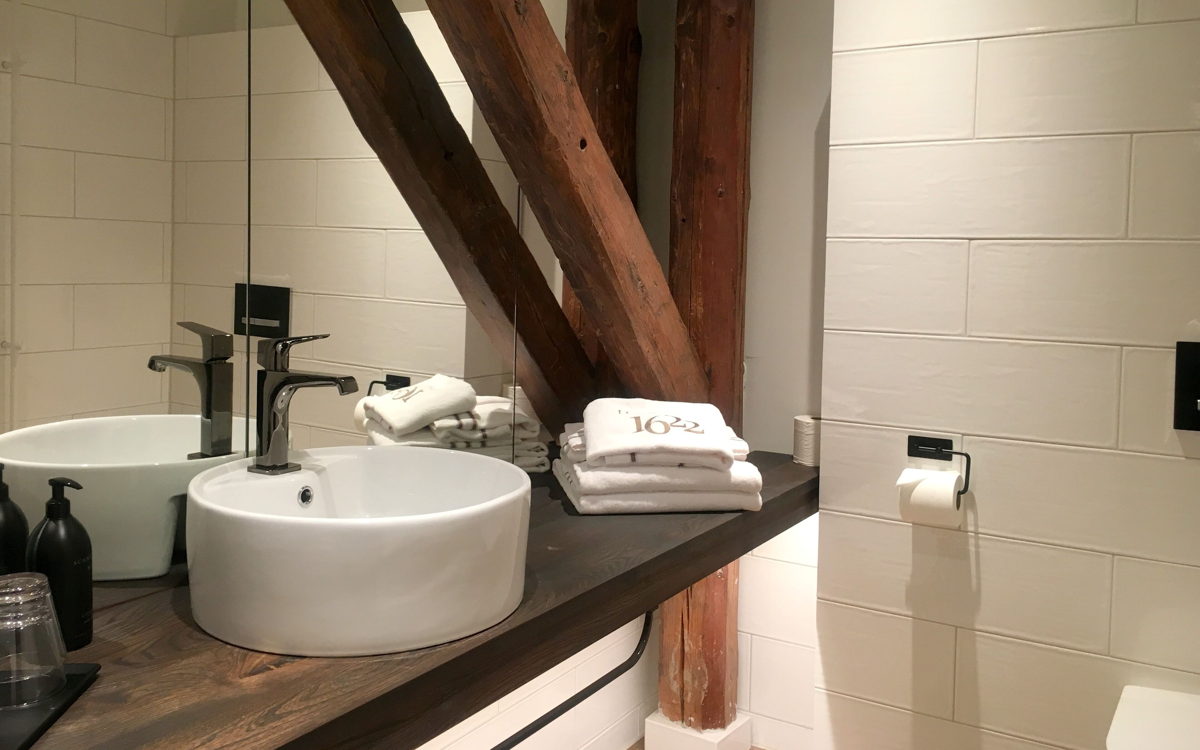 Une salle de bain avec deux lavabos, un miroir et un porte-serviettes.