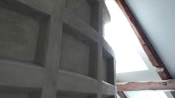 A ceiling with a grid pattern and wooden beams.