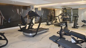 A modern gym with various exercise equipment, including treadmills and weight machines, and large mirrors on the walls. - Flower Town Hôtel & Spa (Rabat)