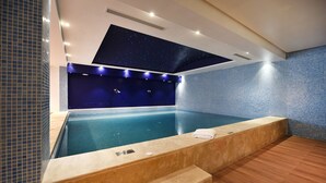 A modern indoor swimming pool with a starry ceiling, blue-tiled walls, and a wooden floor. - Flower Town Hôtel & Spa (Rabat)