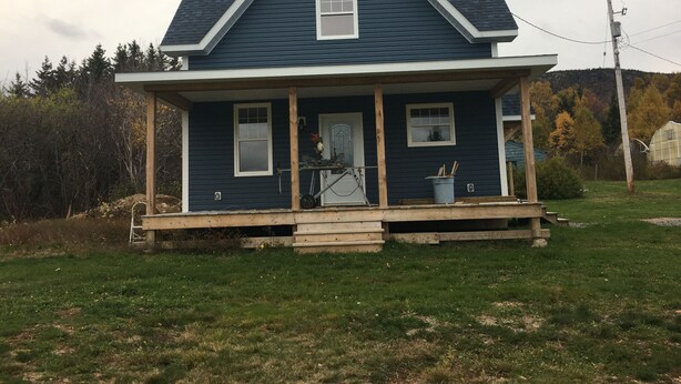 A two-story house with a porch, a garage, and a small shed. - New! Fabulous Farmhouse (Cape Dauphin)