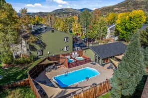 A residential property with a swimming pool, outdoor seating, and a deck area. - Whistler Ge - Sequoia 10 2 Bedroom Condo by RedAwning (Steamboat Springs)