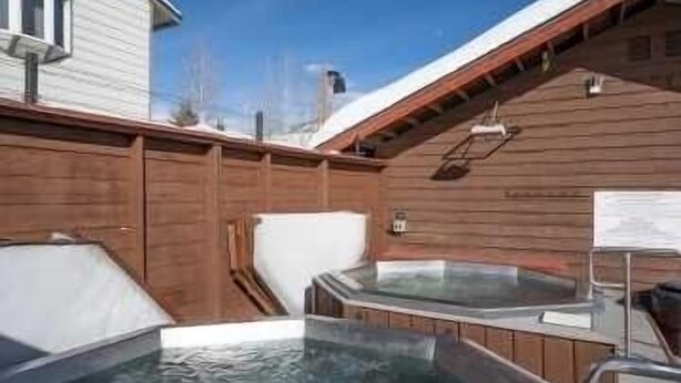 Ein Whirlpoolbereich mit Holzwänden und freiem Blick zum Himmel.