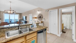 A modern kitchen with granite countertops, stainless steel appliances, and a dishwasher. - 🏖️ Walk2Beach-Gulf Views-2 Pools + Kids Fountain-2BR Ariel Dunes I 1408🏖️ (Miramar Beach)