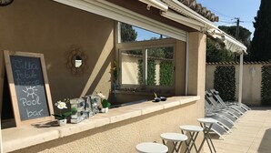 An outdoor bar area with a chalkboard sign, outdoor seating, and a view of the surrounding greenery. - Charming 220m² Villa, 5 bedrooms, pool (heated), in Provence, 4-star **** rated (Bollène)