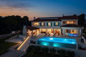 Una casa grande con piscina, varias habitaciones y un patio cubierto.