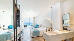 A modern hotel room with two beds, a large bathroom with a sink, and a view of the sea. - Flamingo Paradise Beach Hotel Adults Only (Paralimni)