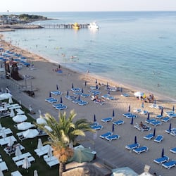 On the beach, white sand, sun loungers, beach umbrellas
