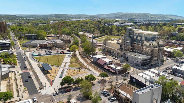 An urban area with a mix of commercial and residential buildings, a central roundabout, and a railway track.