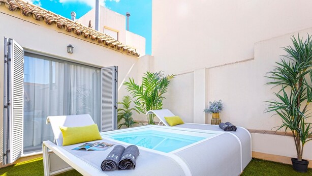 A bedroom with a large bed, a small pool, and a sliding glass door. - Genteel Home Palacio Abades Terrace III (Sevilla)