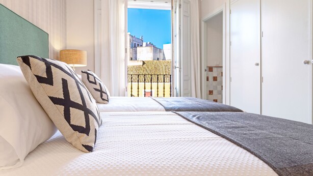 A hotel room with a bed, a view of the outside, and a wardrobe. - Genteel Home Palacio Abades Terrace II (Sevilla)