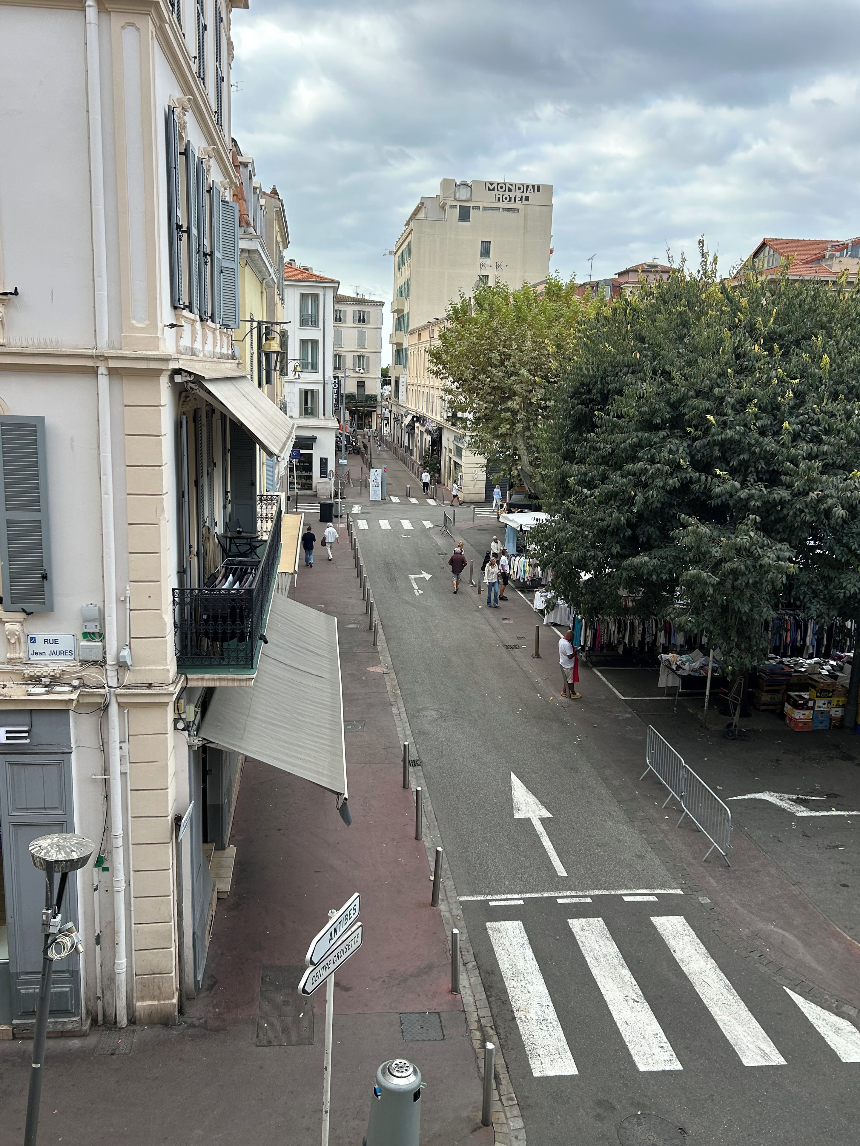A street view with buildings, a crosswalk, and pedestrians.
