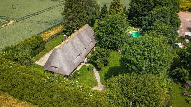 A house with a thatched roof, surrounded by dense greenery and a swimming pool. - Beautiful cottage with heated swimming pool and large unoverlooked garden (Malleville-sur-le-Bec)