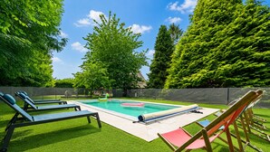 A swimming pool with lounge chairs, artificial grass, and trees in the background. - Beautiful cottage with heated swimming pool and large unoverlooked garden (Malleville-sur-le-Bec)