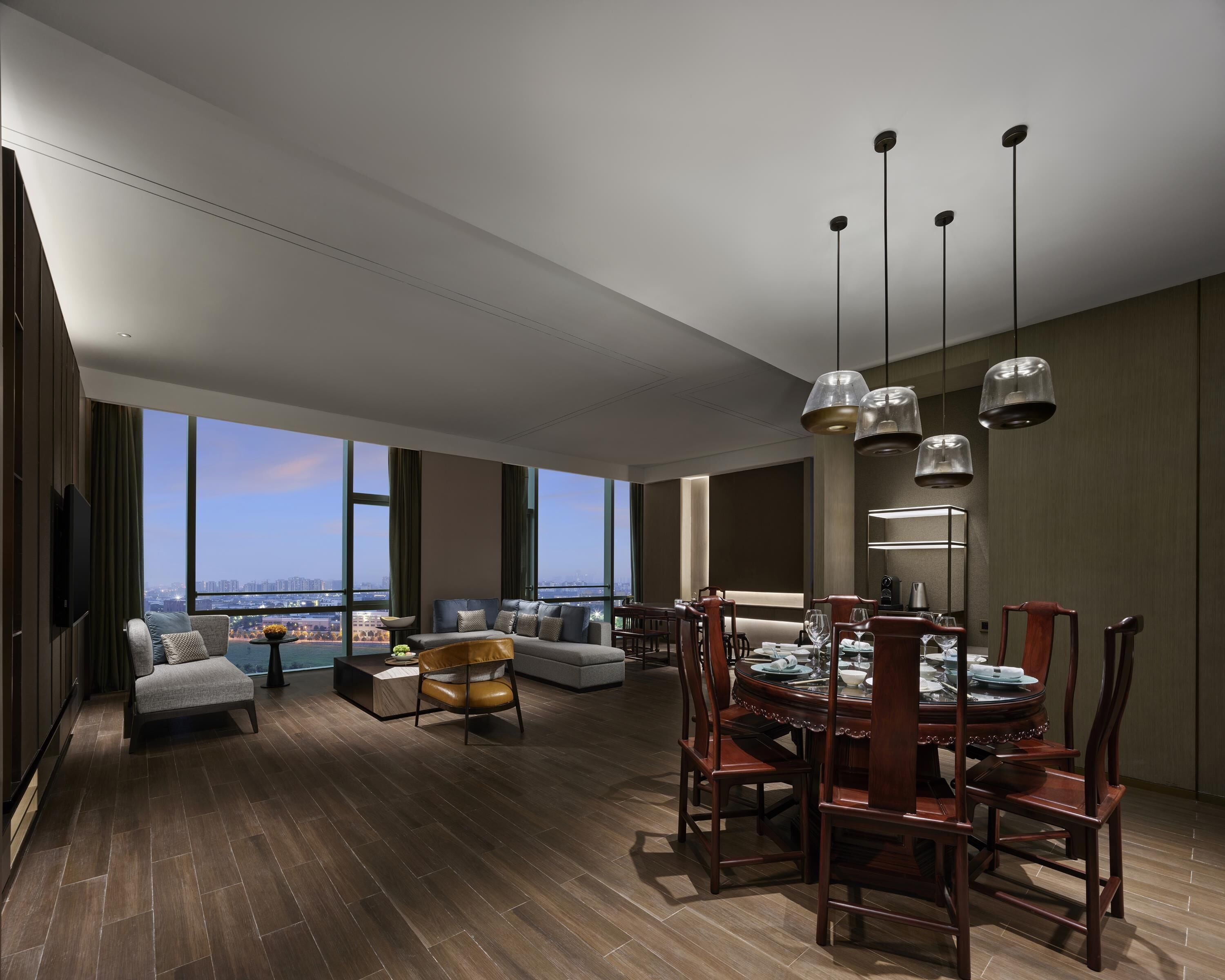 A spacious living area with a dining table, chairs, and a sofa.