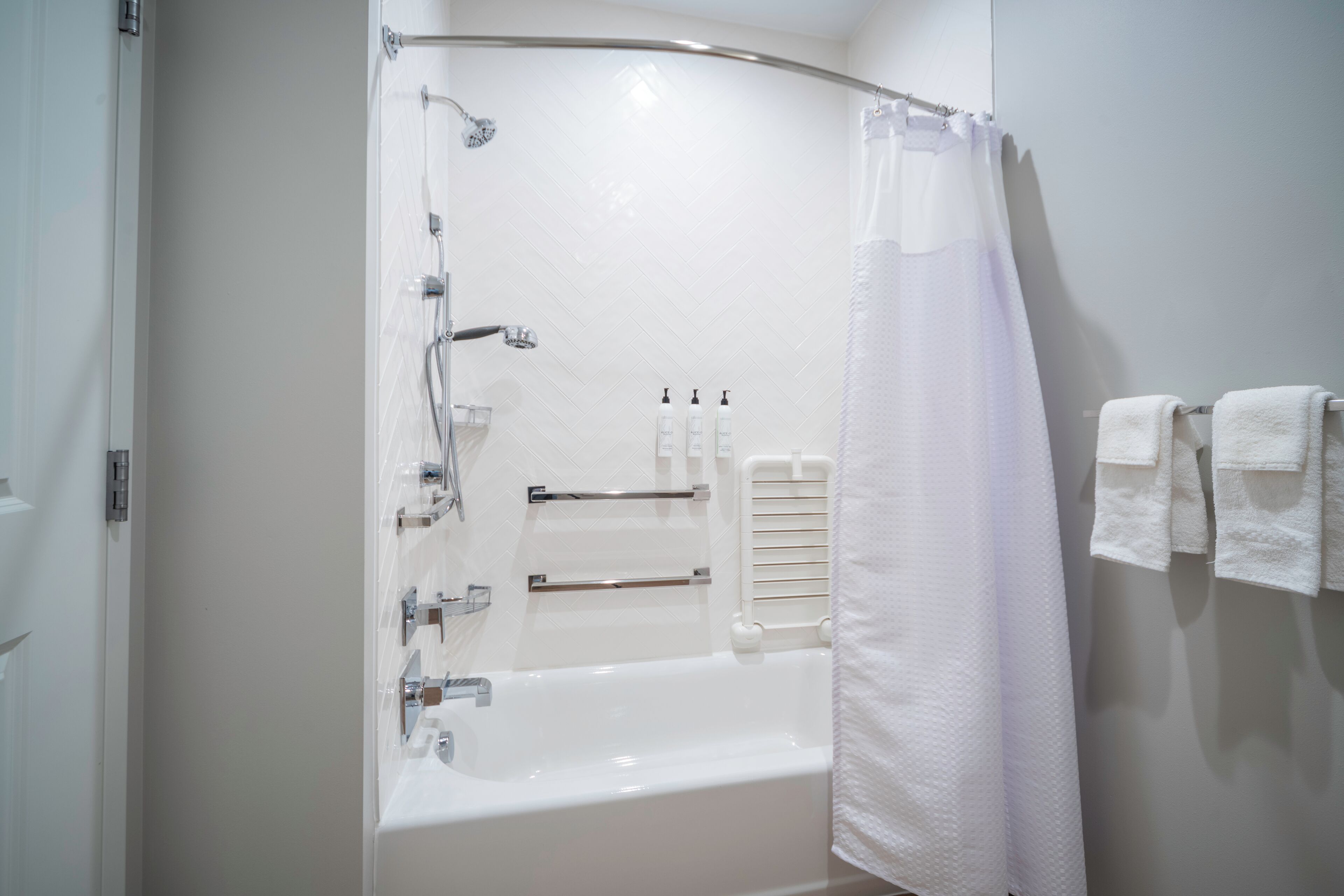 Un baño moderno con bañera, ducha y toallero.