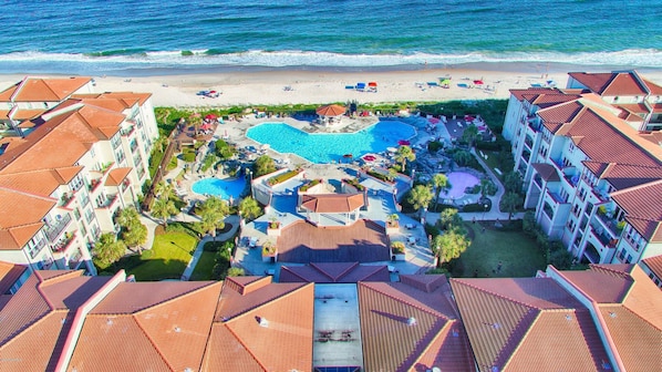 A resort with multiple swimming pools, beach access, and a view of the ocean.
