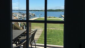 A view through a window of a marina with boats, a grassy area, and a dock.