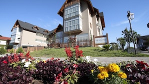 A hotel with a modern design, featuring a prominent balcony and large windows. - Hotel Villa Aconchego (Gramado)