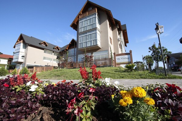 A hotel with a modern design, featuring a prominent balcony and large windows. - Hotel Villa Aconchego (Gramado)