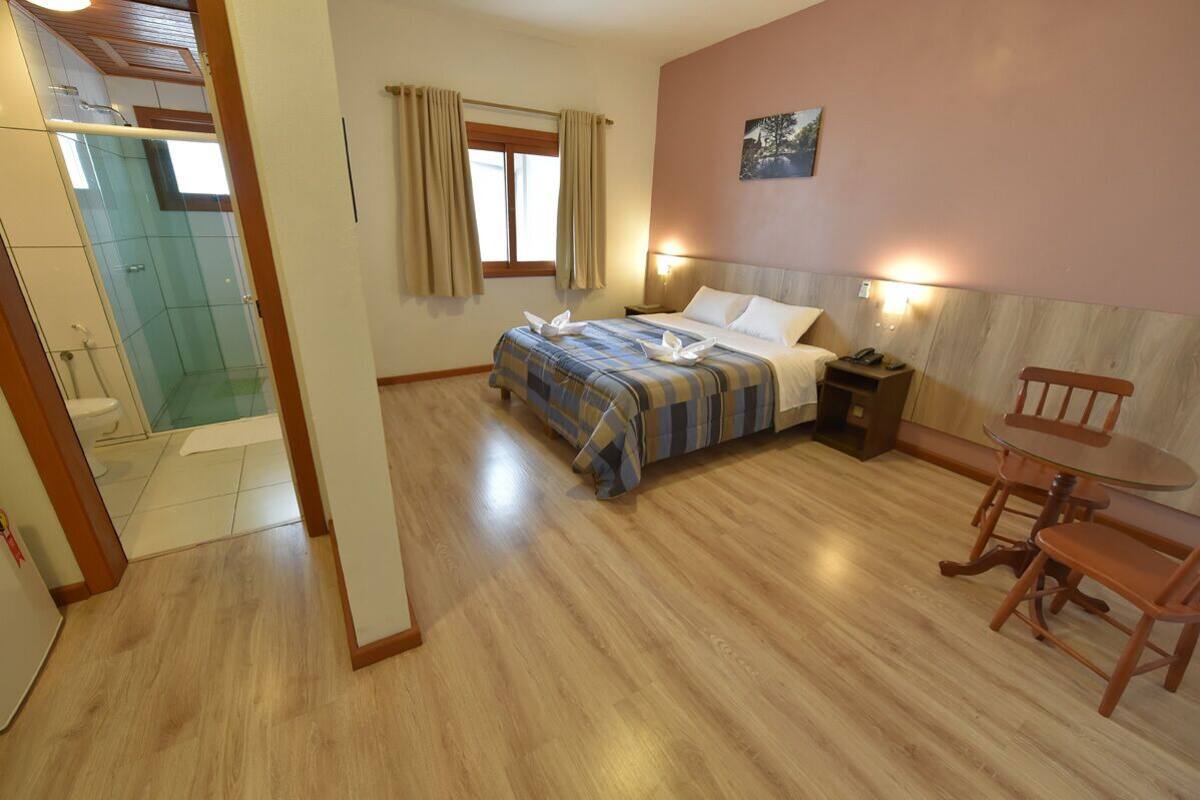 A bedroom with a bed, bedside table, and a small table with chairs.