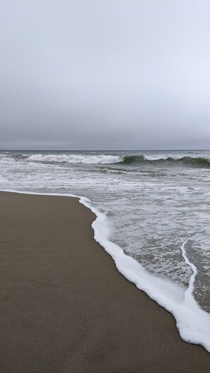 A beach with waves approaching the shore.