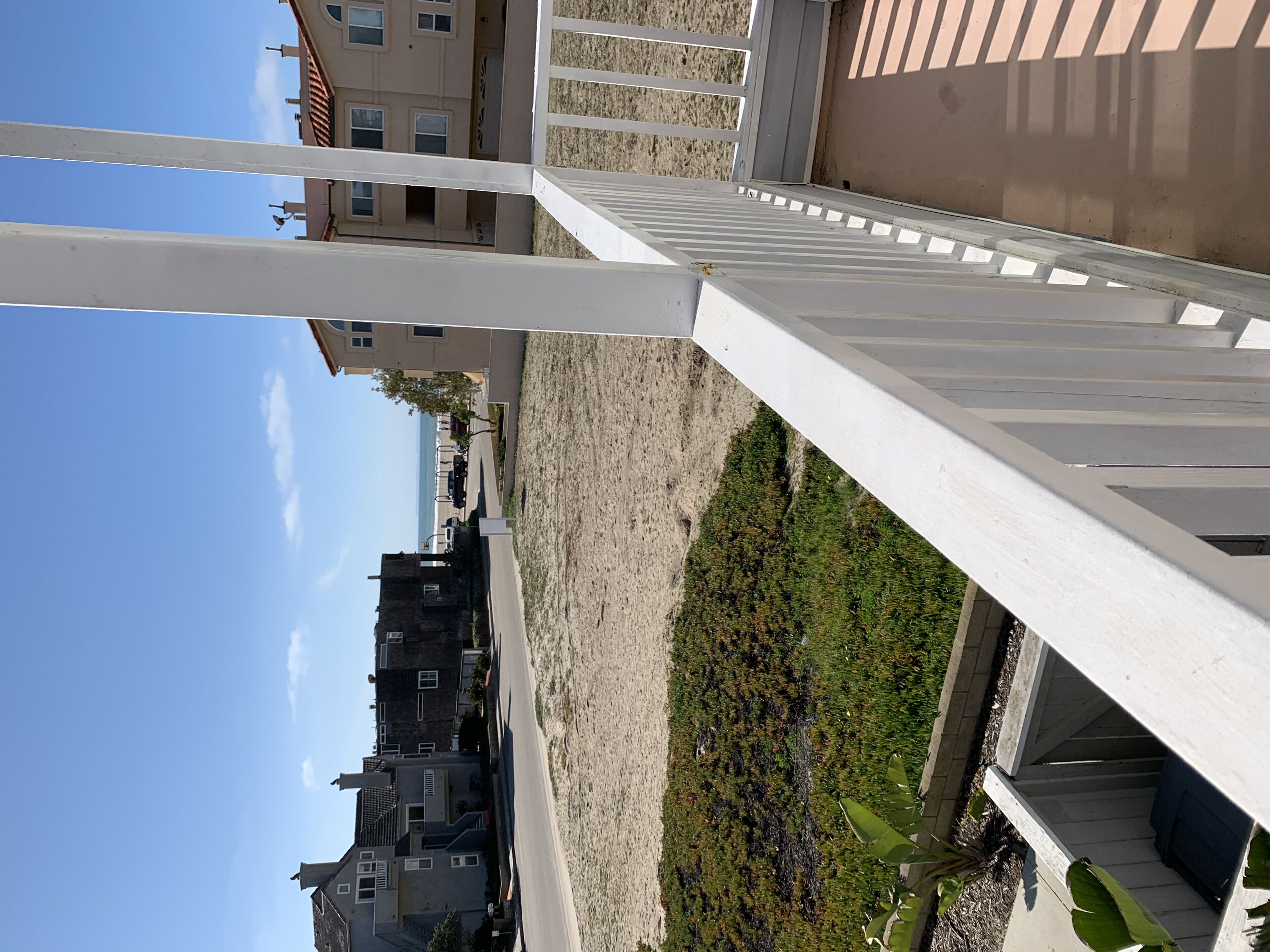A balcony with a view of a landscaped area and buildings in the background.