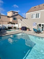 Una piscina al aire libre, sombrillas, sillones reclinables de piscina
