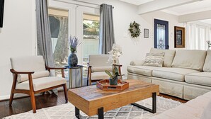 A living room with a sofa, two chairs, a coffee table, and a view of the outdoors. - Designer’s home- Medical Center, Galleria, NRG. Lilly’s Maison 5 (Houston)