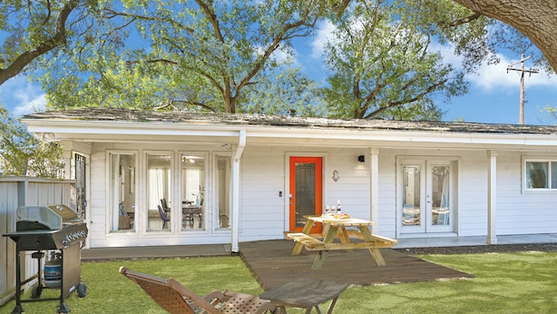 A single-story house with a covered patio, a barbecue grill, and a dining table. - Designer’s home- Medical Center, Galleria, NRG. Lilly’s Maison 5 (Houston)