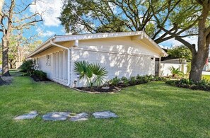 Situated in a quiet residential neighborhood, this charming house features a single-story design with a gabled roof and a cozy front porch.