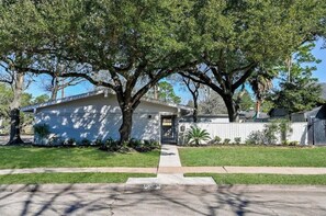 Stroll up to this charming single-story home, surrounded by a lush lawn and mature trees, and enter through the front door.