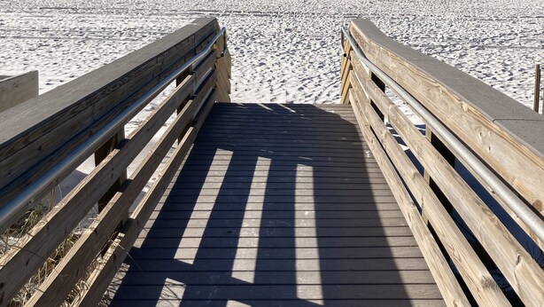 A wooden boardwalk leading to a sandy beach with a clear blue sky. - Updated Coastal Condo • Steps to Beach • Pool • King + Bunks • Ground Floor (Fort Walton Beach)