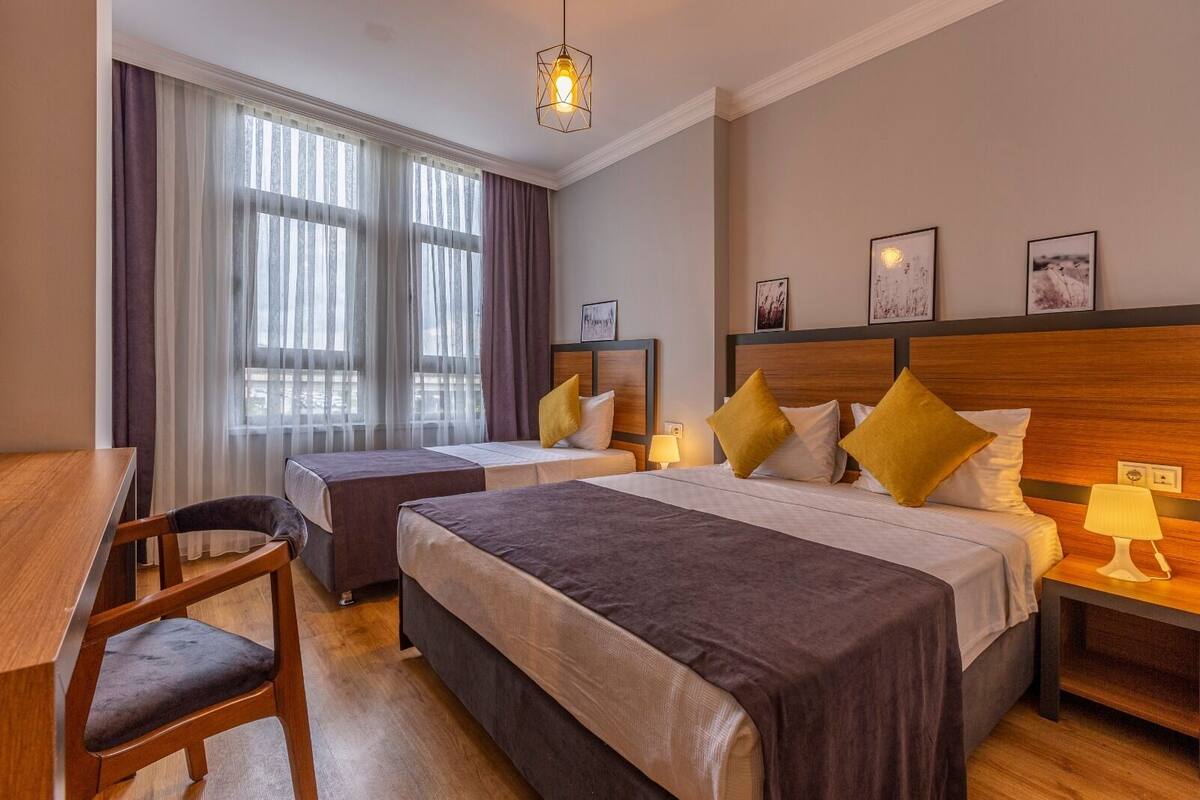 Ein Hotelzimmer mit zwei Betten, einem Schreibtisch und einem Stuhl.