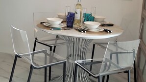 A dining area with a round table, clear chairs, and a large mirror above. - LUX! Jr ONE BD AT ESJ TOWERS, VIEW,LOCATION,SO CHIC! (Carolina)