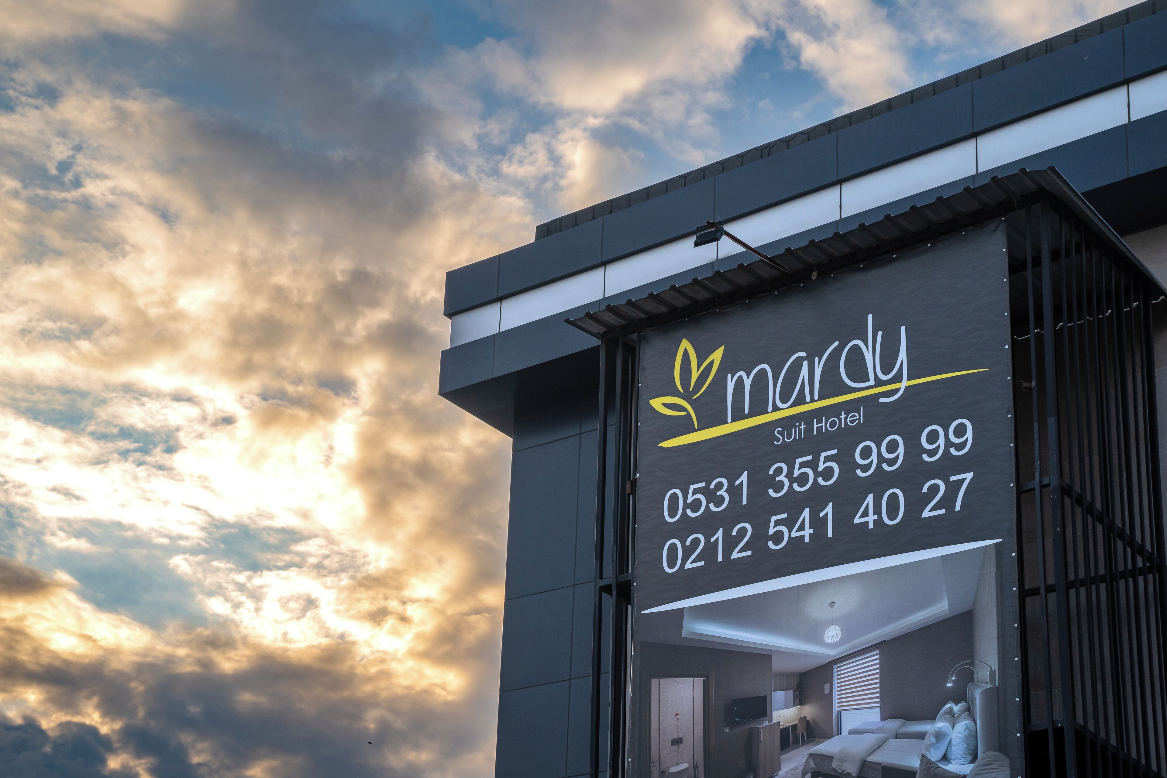 A hotel sign with the name 'Mardy' and contact numbers.