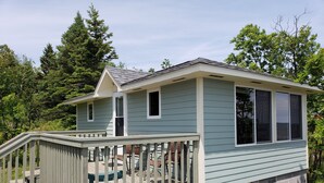A single-story house with a front deck, a small porch, and a garage. - Superior Reflections  Cabin #2 on Lake Superior (Schroeder)