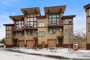 A multi-story residential building with a modern design, featuring large windows and balconies.