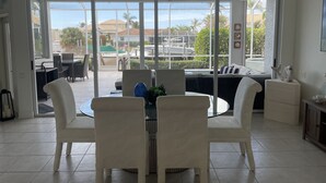 Amplia habitación con un gran ventanal corredero que da a un área exterior con piscina y sillas de descanso.