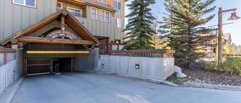 Un bâtiment dont l’entrée, en bois, est signalée par les inscriptions « ENTRÉE DU PARKING » et « BUFFALO DAIRY SILVERMINN ».