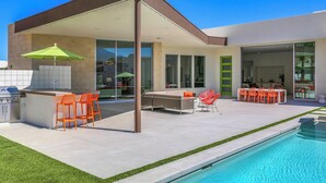 Eine moderne Außenpatio mit Pool, Bar und Sitzgelegenheiten.