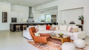 Ein modernes Wohnzimmer mit einem weißen Sofa, einem braunen Ledersessel und einem Glastisch.