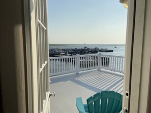 A view from a balcony with a white railing, overlooking a marina with several boats docked. - Bay front in Beach Haven Terrace-3 boat slips, game room tons of new renovations (Long Beach)