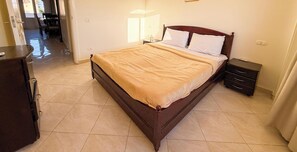 Ein Schlafzimmer mit Bett, Nachttisch und Kommode.