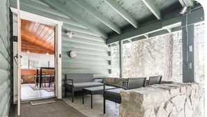 Un espace extérieur abrité, doté de murs en pierre et d’un plafond en bois.