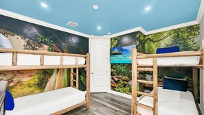 A room with bunk beds, a door, and a mural of a tropical beach scene. - Grand Traverse Paradise | 8-Bedroom Villa w/ Private Pool at Reunion Resort (Kissimmee)