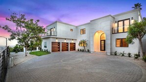 A modern two-story house with a driveway, garage, and landscaped garden. - The Light of Mount Olympus (Los Angeles)