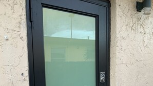 A black door with a frosted glass panel and a keypad lock. - Everything is pretty much walking distance which is odd for Miami  (Hialeah)