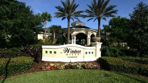 A sign for Windsor Hills with a landscaped garden and palm trees. - Windsor Wonderland!  Your Disney Getaway! Water slides, pool, arcade and more! (Kissimmee)