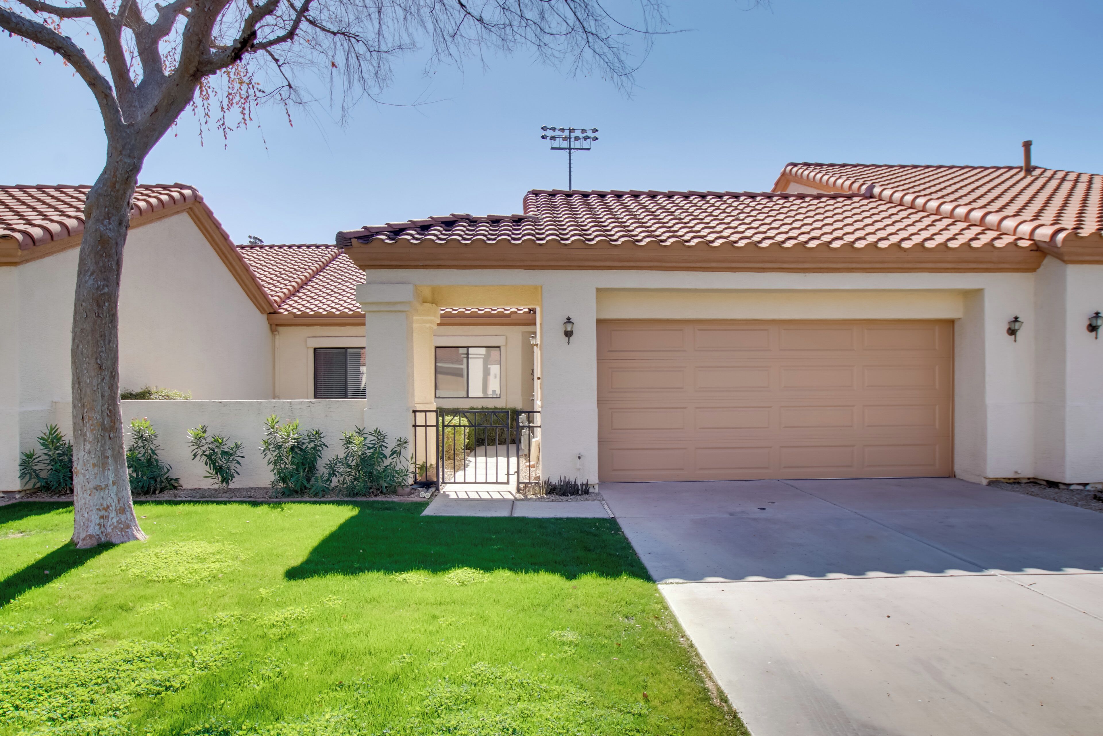 A residential house with a tiled roof, a garage, and a well-maintained lawn.
